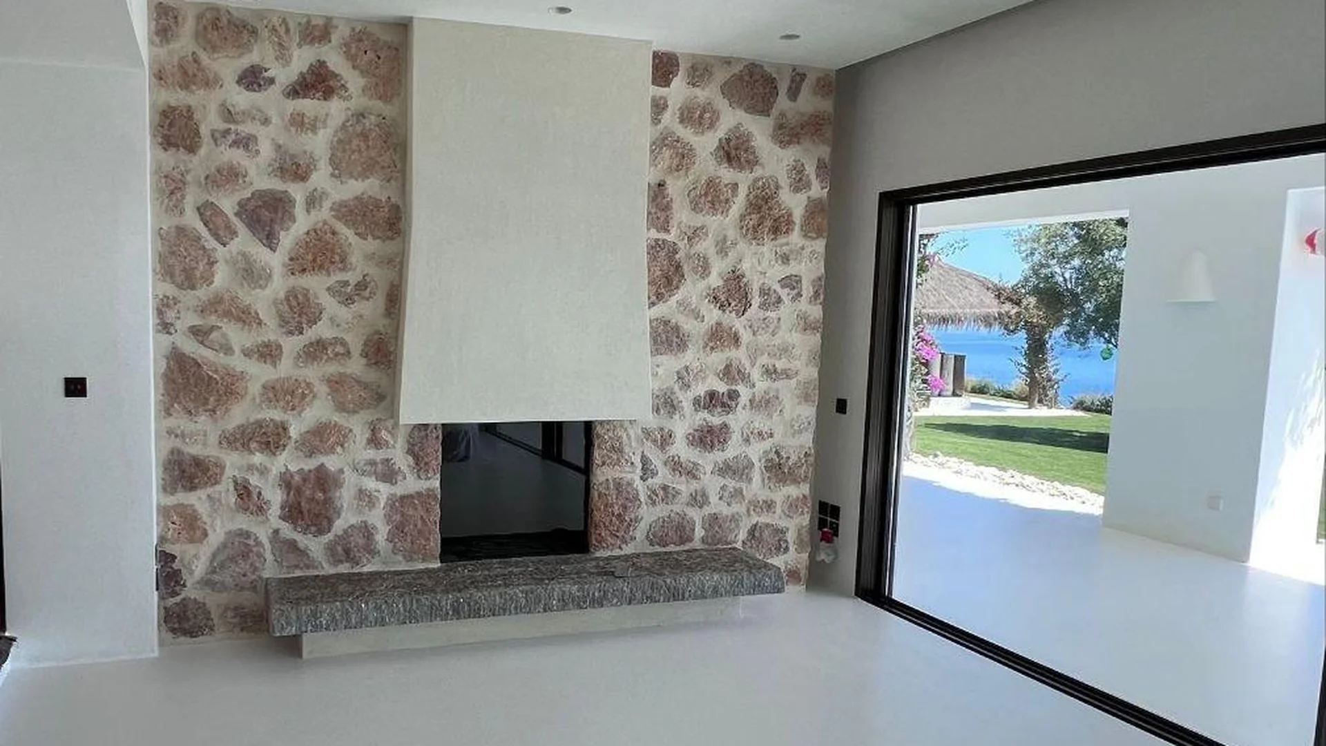 Reforma de villa en Ibiza — chimenea de piedra con vistas al mar