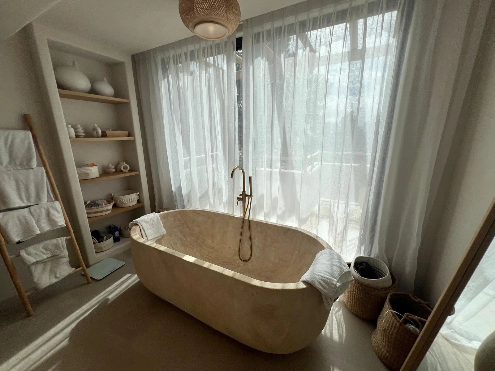 Bathroom renovation Ibiza — freestanding travertine bath and brass fittings