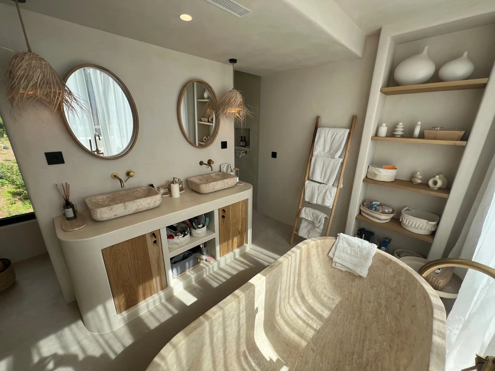 Suite master con doble lavabo en travertino, bañera exenta y mármol — Ibiza